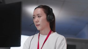 Young Asian call center woman wearing headset and microphone while working at computer in modern office. Professional customer support representative providing online assistance, technical help - Powered by Shutterstock - Get 15% off with code: PIKWIZARD15