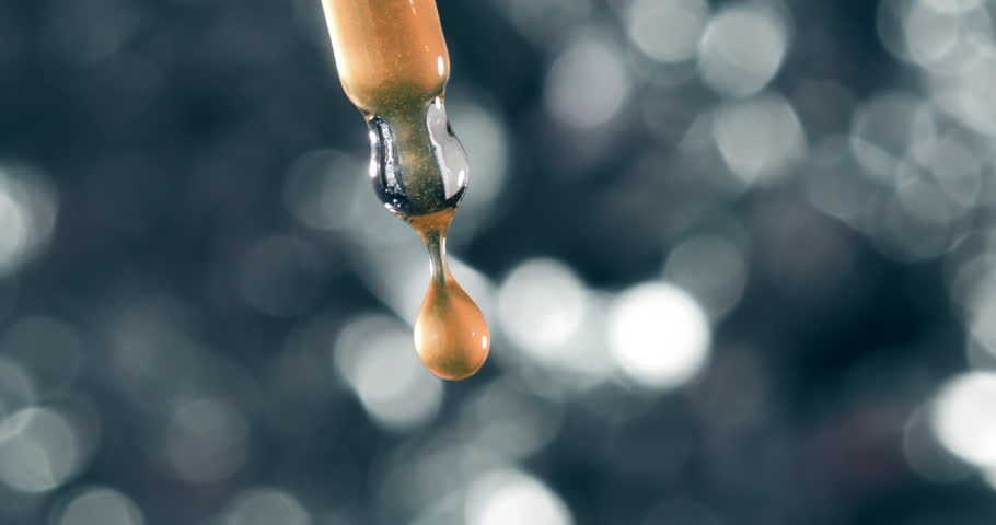 Golden Liquid Droplet Falling from Cosmetic Dropper in Ultra Slow Motion at 1000fps. Vitamin C Serum, Skin Elixir, Radiance Booster, Organic Skincare, Essential Oil Concept, Beauty Macro