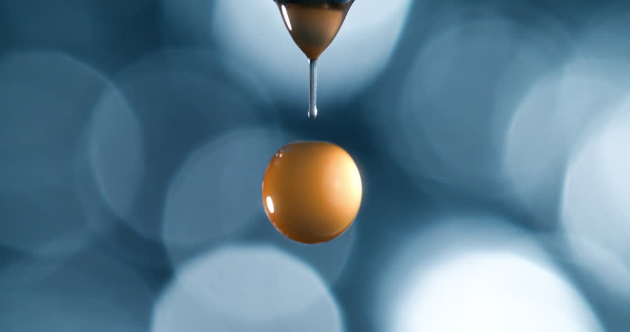 Macro of Golden Liquid Droplet Falling from Cosmetic Dropper in Ultra Slow Motion at 1000fps. Vitamin C Serum, Skin Elixir, Radiance Booster, Organic Skincare, Essential Oil Concept, Beauty Macro