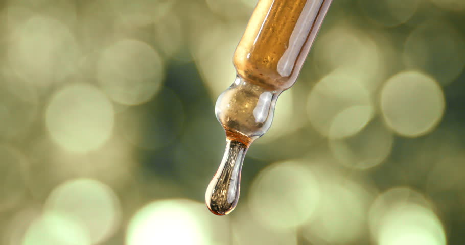 Macro of Honey-Colored Liquid Dropping Slowly from Glass Dropper at 1000 fps. Nourishing Facial Serum, Natural Beauty Elixir, Anti-Aging Skincare, Hydration Essence Macro, Wellness and Glow Concept