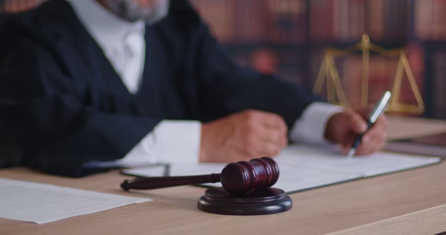 Gavel before judge as symbol of court verdict on case in courtroom and jurisprudence. Wooden hammer lying on block near legal documents, law and justice scales on desk, waiting decision during trial