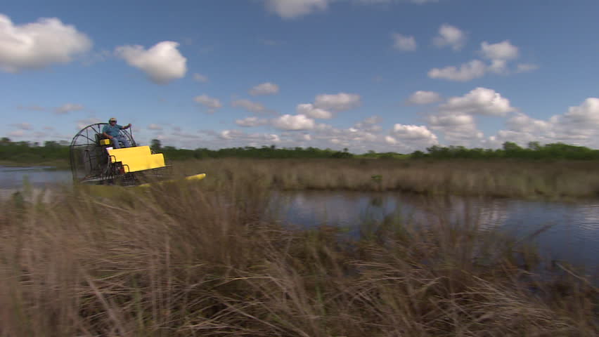 An air boat speeds toward the camera in the Florida everglades