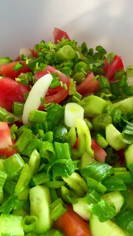 Macro shot of a salad with fresh vegetables and herbs. Freshly made Mediterranean salad on plate. 