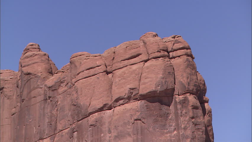 Pan across cliff face from below