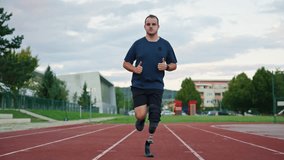 Man with disability wearing a prosthetic leg with a blade running on an outdoor athletic track, slow motion front view. Challenge and inspiration concept. - Powered by Shutterstock - Get 15% off with code: PIKWIZARD15