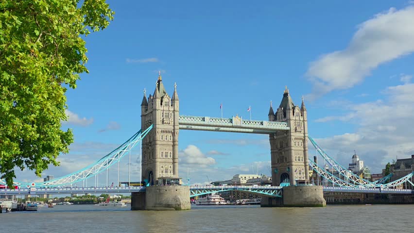 Classic summer view of the Tower Bridge across the Thames, London, UK. Handheld, panning motion.