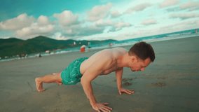 young muscular athlete man do push-ups workout at sunny beach outdoor, person exercising push up by sea 4k - Powered by Shutterstock - Get 15% off with code: PIKWIZARD15