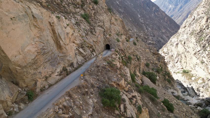 Huaraz, Peru: Aerial drone footage capturing bus driving out of tunnel of Canon del Pato in Huaraz, Peru. With forward motion, showing the bus in narrow road between cordillera blanca and negra