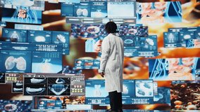 Portrait of healthcare specialist looking at CT scans, MRI data, and lab analytics displayed on videowall. Scientist in medical research lab reading health data on high tech digital panels, camera A - Powered by Shutterstock - Get 15% off with code: PIKWIZARD15