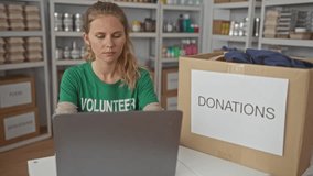 Focused woman uses laptop for typing in a warehouse surrounded by blonde young volunteer smiling near donations box at charity center. - Powered by Shutterstock - Get 15% off with code: PIKWIZARD15