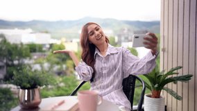 Asian adult woman enjoys smartphone interaction creates content. Sitting on modern home balcony. Capturing city mountain scenery activity. - Powered by Shutterstock - Get 15% off with code: PIKWIZARD15