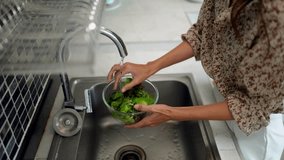 Asian adult woman hand preparing fresh salad greens in a bowl using kitchen faucet water promoting hygiene nutrition and wellness through sustainable habits - Powered by Shutterstock - Get 15% off with code: PIKWIZARD15