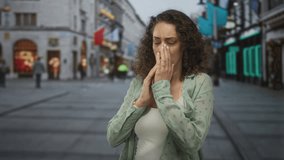 Woman with hand to chest looking over her shoulder on busy city street with storefronts and neon signs; anxiety caution. - Powered by Shutterstock - Get 15% off with code: PIKWIZARD15