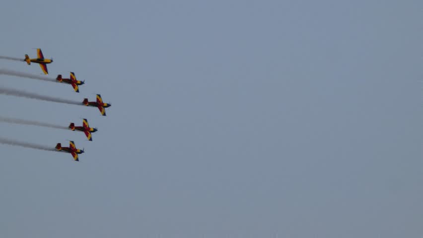 Five colorful Romanian Hawks aerobatic planes fly in parallel formation, leaving vivid smoke trails behind, captured in an ultra-zoom tracking shot.