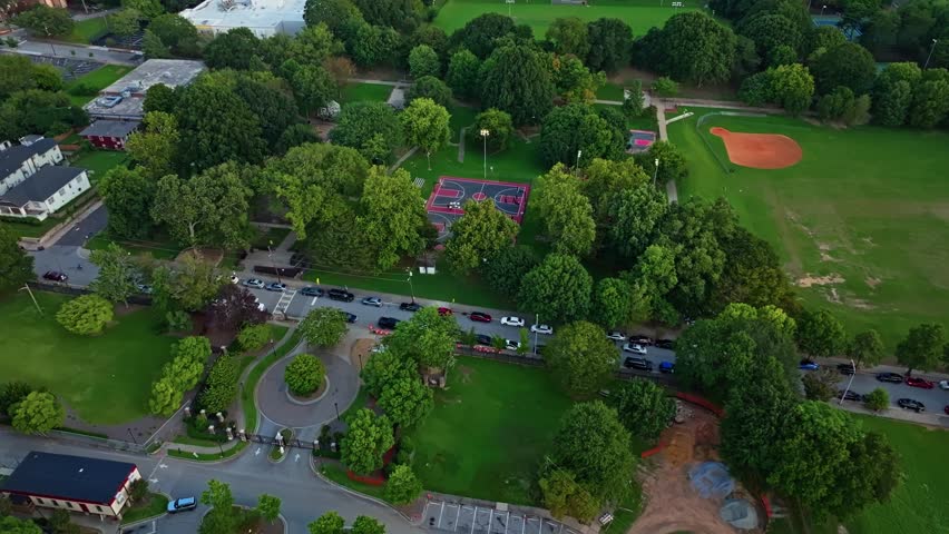 Central Park basketball court, Urban park playground, Atlanta green park neighbourhood, Cars parked in line on road, Georgia, Aerial