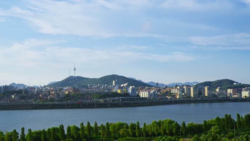Wide aerial view of the Seoul city skyline with the iconic Namsan Tower and the Han River on a beautiful sunny day in South Korea