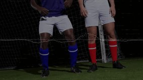 High ball entering above two soccer players heading ball on floodlit turf, competing for possession. Athletic, teamwork, intensity, competition, nighttime, motion, sport - Powered by Shutterstock - Get 15% off with code: PIKWIZARD15