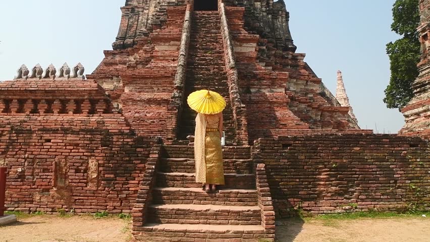 Thailand, Ayutthaya - march 15th, 2023: Woman in traditional Thai dress pose sightseeing visit ancient Buddha statue.Ayutthaya historical park. UNESCO World Heritage Site
