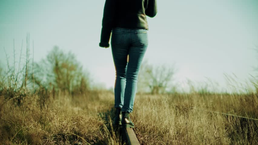 Lonely Woman Feet In Jeans Walking On Rail Road When Train Or Tram Cancelled.Tourist Legs Walking On Railway Middle Of Rail.Girl Walks To Home On Railroad Tracks After Canceled Tram Public Transport 