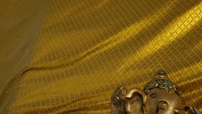 Bronze Ganesha Statue with Golden Cloth at Hindu Temple - Elephant God Holding Musical Instrument - Powered by Shutterstock - Get 15% off with code: PIKWIZARD15