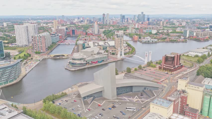 Aerial drone footage of MediaCityUK in Salford, Greater Manchester, England. The scene captures modern glass-fronted buildings. Home to major media studios.