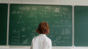 Child Erasing Mathematical Formulas on Chalkboard in Classroom, Student Cleaning Blackboard with Complex Math Equations and Graphs, Education Learning Concept. Class room School. Little boy erasing - Powered by Shutterstock - Get 15% off with code: PIKWIZARD15