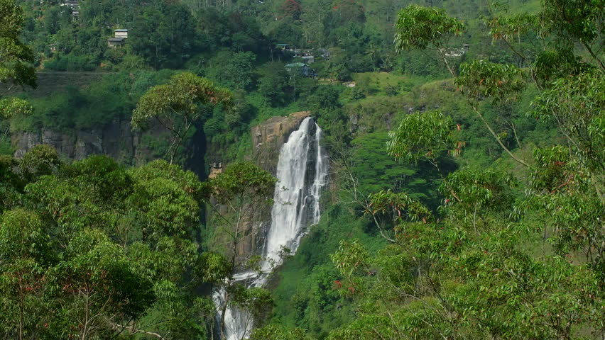 Majestic Devon Falls cascades down a cliff face, surrounded by vibrant green foliage, creating a breathtaking natural spectacle in the heart of Sri Lanka