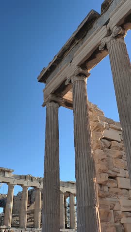 Side perspective of the Parthenon temple on the Acropolis in Athens, Greece, captured during golden hour. ancient marble columns and the harmony of classical architecture against the blue sky. 
