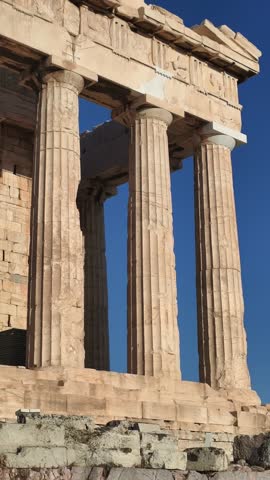 Side perspective of the Parthenon temple on the Acropolis in Athens, Greece, captured during golden hour. ancient marble columns and the harmony of classical architecture against the blue sky. 