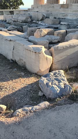 Side perspective of the Parthenon temple on the Acropolis in Athens, Greece, captured during golden hour. ancient marble columns and the harmony of classical architecture against the blue sky. 