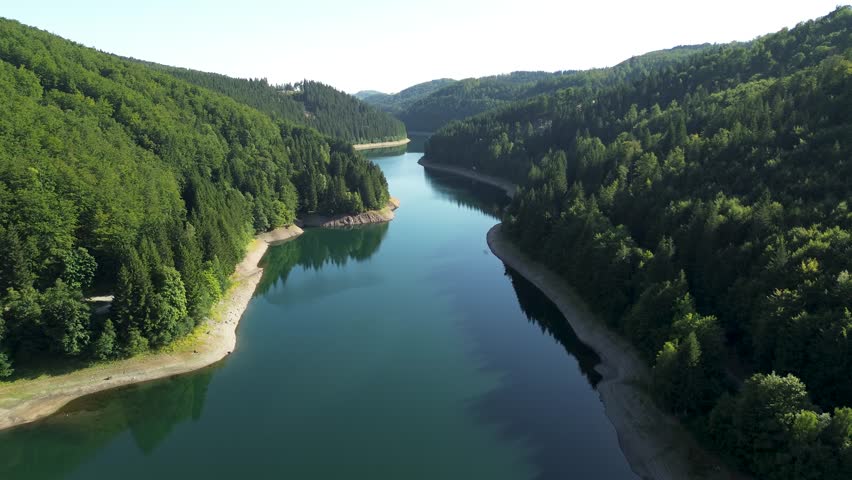 high flight over beautiful blue water river in spruce tree covered mountains landscape