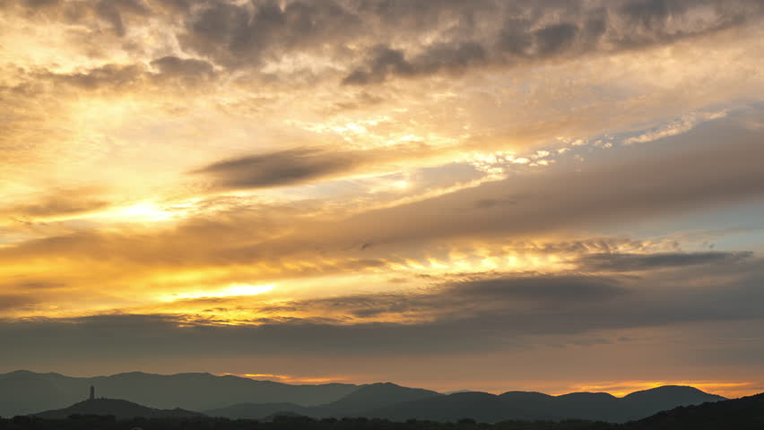 The distant mountains and ancient Yuquan Pagoda at Yuquan Mountain in Beijing, China, beneath the evening clouds and sunset glow