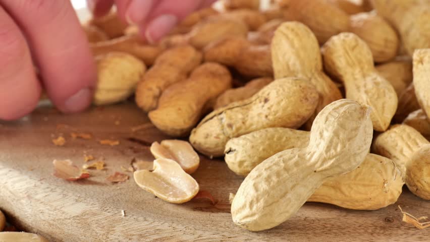 Peanuts. Groundnuts. Peanut cleaning process.Close-up of fingers peeling peanut kernels from their shells.A delicious and healthy snack. Peanut butter ingredient.Plant-based protein source. 4k footage