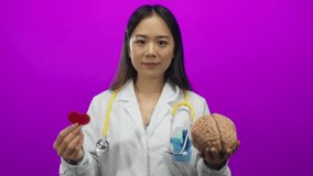 Young woman doctor with stethoscope holds brain and heart paper against pink background, symbolizing medical science and healthcare choices. - Powered by Shutterstock - Get 15% off with code: PIKWIZARD15