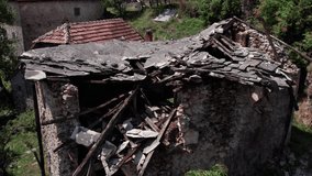 Aerial footage of ruined stone house with collapsed roof and wooden beams in deserted mountain village - Powered by Shutterstock - Get 15% off with code: PIKWIZARD15