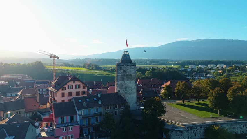 Aerial view of Orbe cityscape, where the tower with the flag stands tall amidst the buildings under a serene sky, Orbe, Vaud, Switzerland.