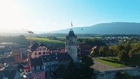 Aerial view of Orbe cityscape, where the tower with the flag stands tall amidst the buildings under a serene sky, Orbe, Vaud, Switzerland. - Powered by Shutterstock - Get 15% off with code: PIKWIZARD15
