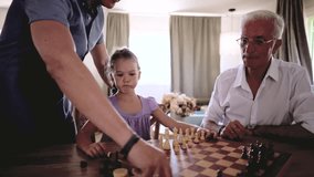 Multi generational family with a grandfather, father, and young daughter playing a game of chess, sharing a moment of learning and bonding together while developing intellectual skills at home - Powered by Shutterstock - Get 15% off with code: PIKWIZARD15