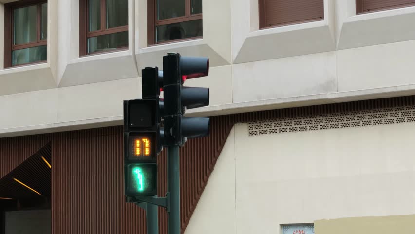 Pedestrian Traffic Light with Countdown Timer Showing Seconds Remaining, Green Walking Man Symbol and Numeric Digital Display for Crossing Street Safety, Modern Urban Technology