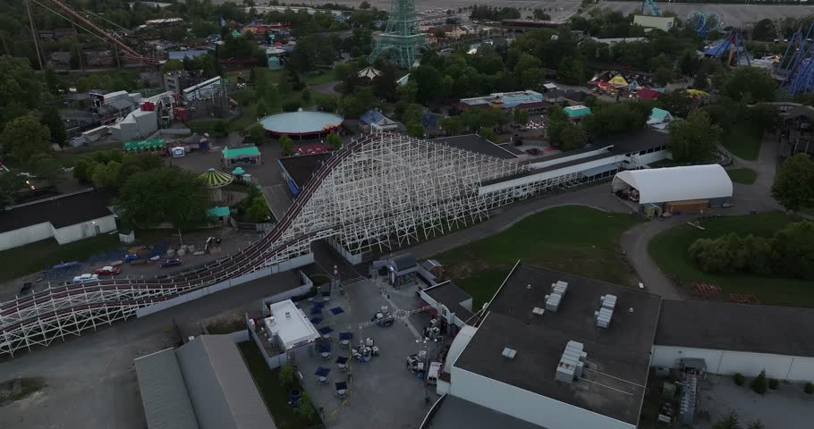 Aerial view of a wooden roller coaster and the Eiffel Tower replica at Kings Island under a dusky sky casting long shadows, Mason, Ohio, United States.