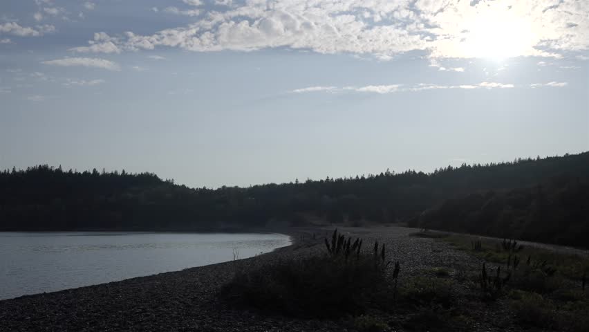 Calm and serene pebble shoreline of Jasper Beach in Maine on a hazy sun day