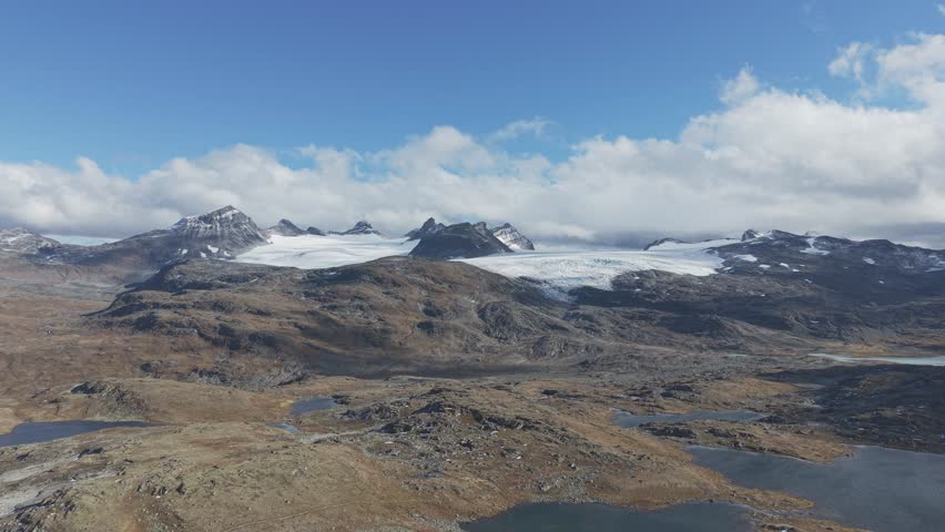 Flying towards mountain peaks and glaciers in Jotunheimen National Park, Norway