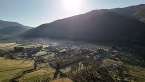 Sun rising from behind the rolling hills of picturesque Italian countryside, morning mist covering small rural village at the hillside, panoramic view of fertile soil fields with growing cypresses - Powered by Shutterstock - Get 15% off with code: PIKWIZARD15