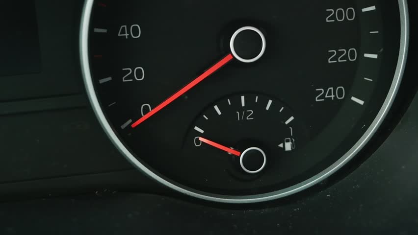 Empty fuel tank warning light glows on modern car dashboard, indicating critical low gas level and urgent need for refueling.