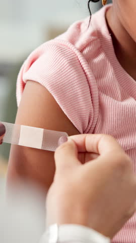 Plaster, doctor and girl in clinic, hands and first aid with healthcare, immunization shot and wellness. Pediatrician, patient and child in hospital, wound protection and bandage for medical checkup