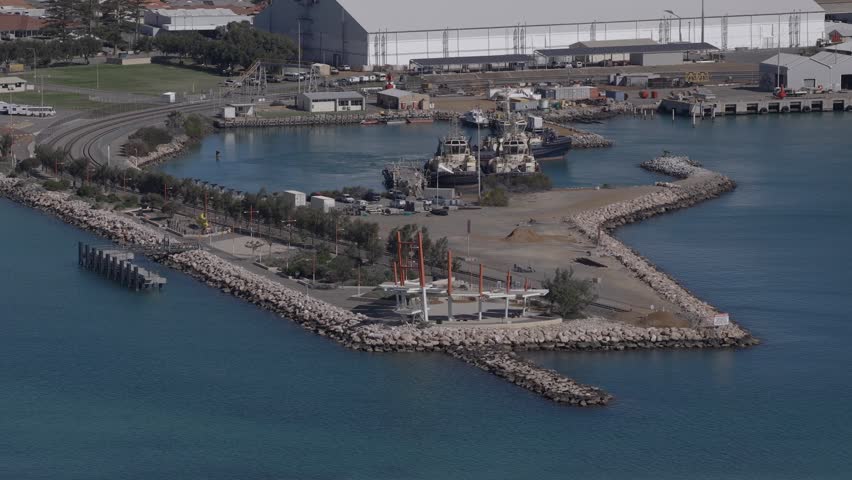Aerial shot of a tugboat departing from its dock behind Geraldton esplanade.