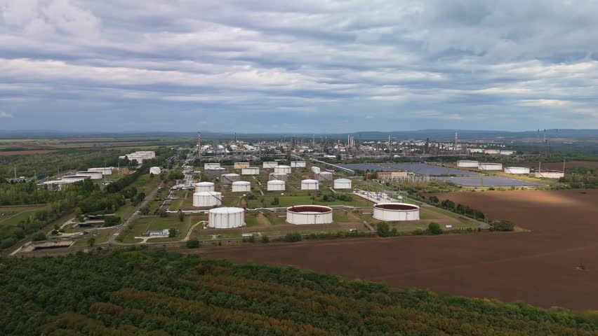 Reversing drone view of the Mol Danube Oil Refinery in Százhalombatta, Hungary, with its industrial facilities and storage tanks.