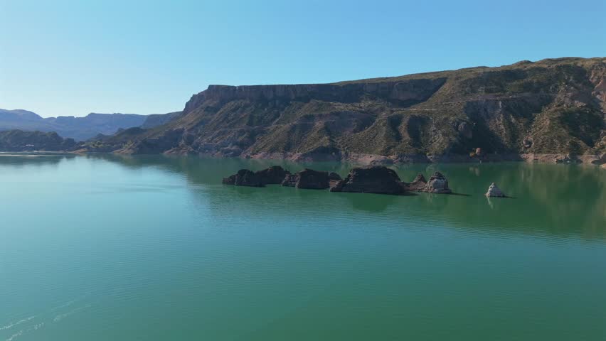 Aerial fly Emerald Lake Landscape in Mendoza Argentina, Atuel Canyon, Valle Grande Reservoir along Rugged Cliffs