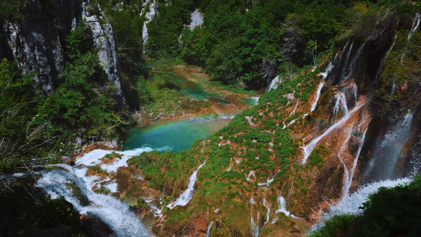 Clear spring river waterfall cascading through forest in Plitvice Lakes National Park, Croatia