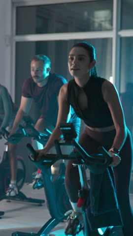 Bike, fitness and woman in gym, wellness and night with cardio training, workout and challenge. Healthy people, endurance and machine in studio, exercise and breathing with energy, motion and cycling